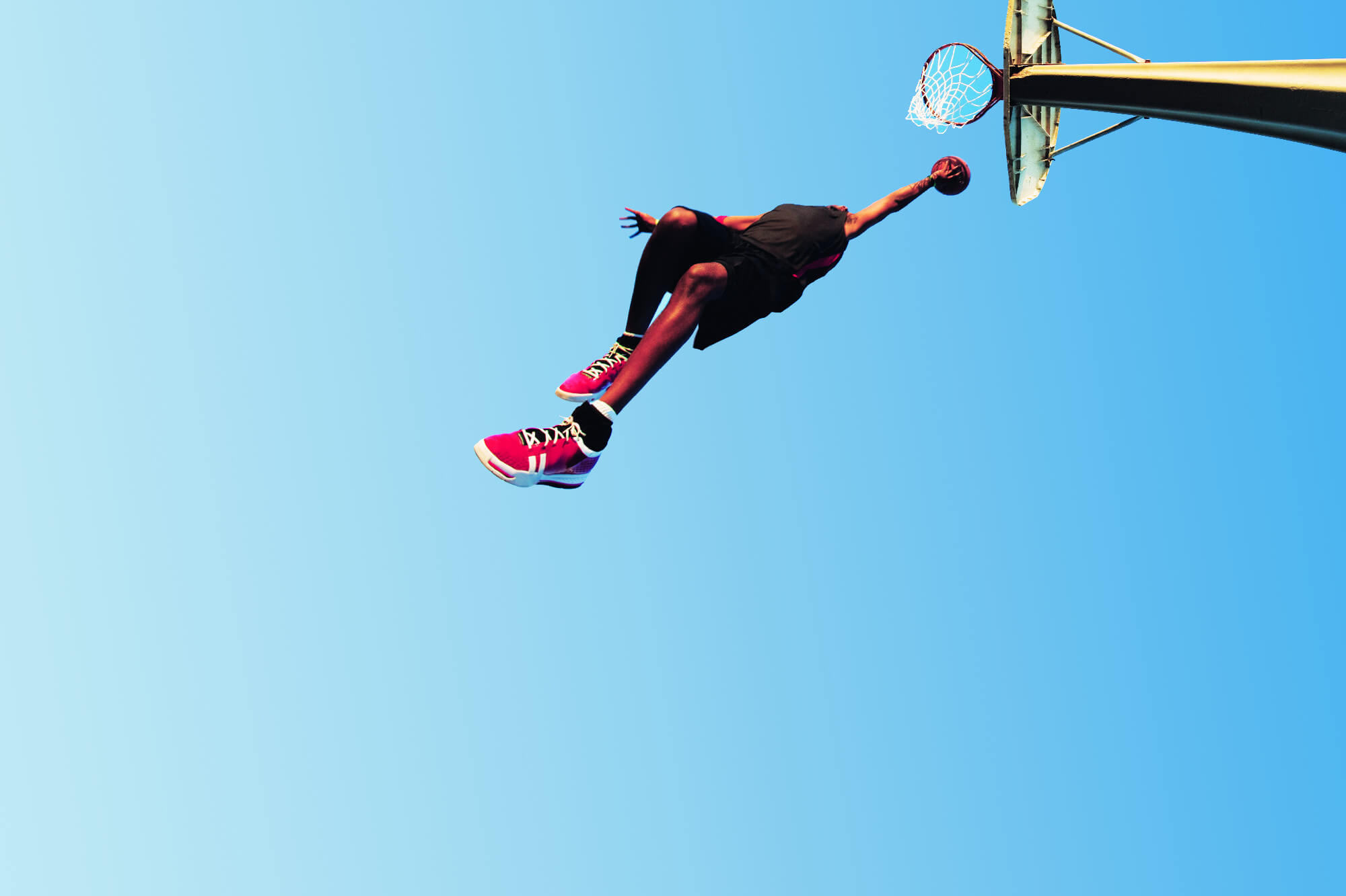 Photo of basket ball payer leaping to the sky and scoring in the hoop