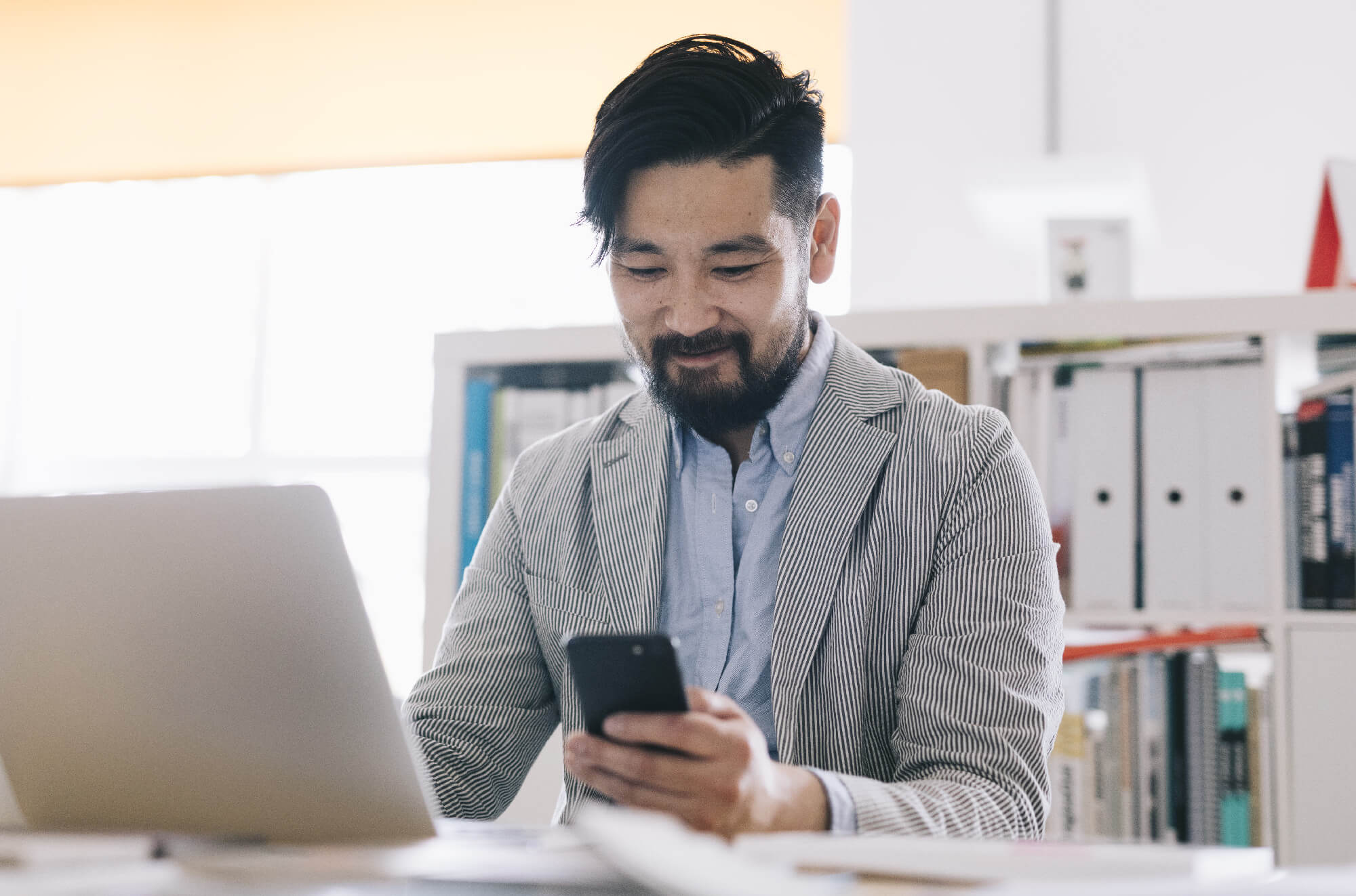 Photo of Experian customer checking his smartphone at work.