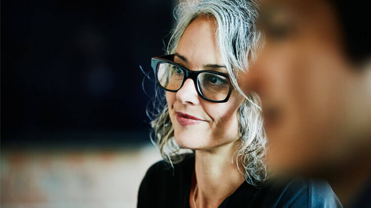 Woman wearing glasses participating in a meeting