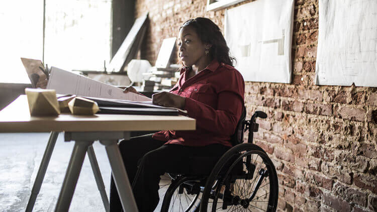Woman in a wheelchair sitting a desk