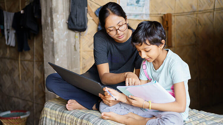 Woman helping a young child go through a packet of information