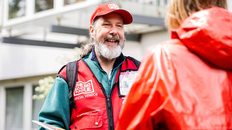 The Big Issue employee talking to a member of the public 