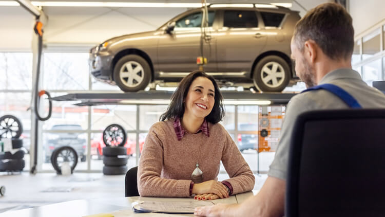 A customer talking to a sales representative at a car sales business